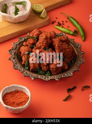 Hähnchen 65 Hähnchenstarter mit einer knusprigen Beschichtung aus indischem Masala-Teig, in Öl frittiert, würzig und heiß serviert. Stockfoto