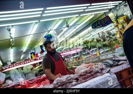London - August 2022: Halal Metzger auf der Electric Avenue, einer berühmten multikulturellen Straße in Brixton mit Marktständen und einer lebhaften Atmosphäre Stockfoto