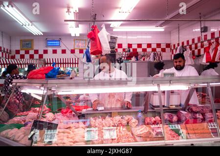 London - August 2022: Halal Metzger auf der Electric Avenue, einer berühmten multikulturellen Straße in Brixton mit Marktständen und einer lebhaften Atmosphäre Stockfoto