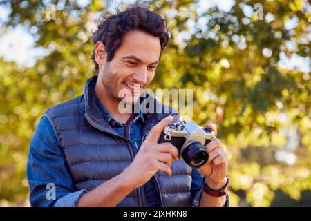Reifer Mann Auf Dem Land Im Herbst, Der Mit Einer Digitalkamera Im Retro-Stil Fotos Zur Veröffentlichung In Sozialen Medien Gemacht Hat Stockfoto