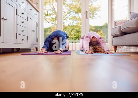 Paar Stretching Auf Matten Zu Hause Tun Yoga-Übungen Zusammen Stockfoto