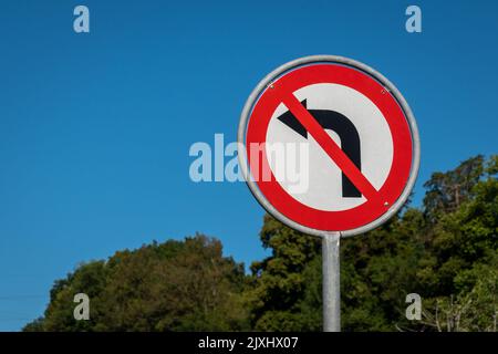 Kein Schild links gegen blauen Himmel. Verkehrszeichen. Es ist verboten, sich nach links zu wenden. Stoppschild. Warnschild. Stockfoto