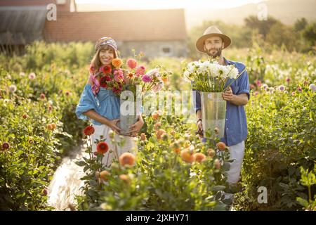 Schönes Paar mit Dahlia Blumen im Garten im Freien Stockfoto