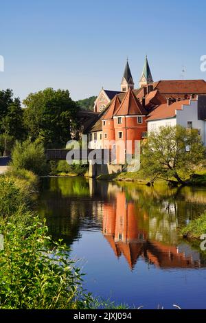 Der farbenfrohe, berühmte Biertor mit der Brücke über den Regen in Cham, einer Stadt in der Oberpfalz, Bayern, Deutschland. Eine Kirche im Hintergrund. Stockfoto