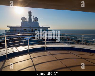 Von der Laufstrecke eines Kreuzfahrtschiffs auf der Nordsee aus sehen wir die Trichter und den Überbau des Schiffes. Es ist später Nachmittag, und das sh Stockfoto