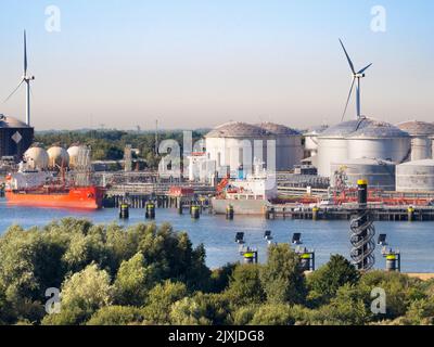Die Vergangenheit und Zukunft der Energieversorgung - Windturbinen und riesige Ölspeicher vor den Toren Rotterdams, Niederlande. Der Hafen von Rotterdam ist die La Stockfoto