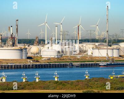 Die Vergangenheit und Zukunft der Energieversorgung - Windturbinen und riesige Ölspeicher vor den Toren Rotterdams, Niederlande. Der Hafen von Rotterdam ist die La Stockfoto