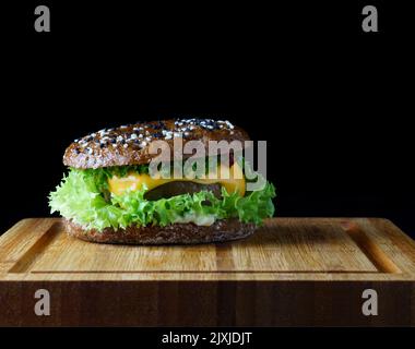 Frische leckere Burger auf dunklem Hintergrund Stockfoto