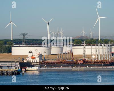 Die Vergangenheit und Zukunft der Energieversorgung - Windturbinen und riesige Ölspeicher vor den Toren Rotterdams, Niederlande. Der Hafen von Rotterdam ist die La Stockfoto