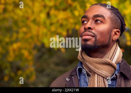 Kopf Und Schultern Porträt Des Menschen Auf Einem Spaziergang Durch Die Herbstliche Landschaft Gegen Goldene Blätter Stockfoto