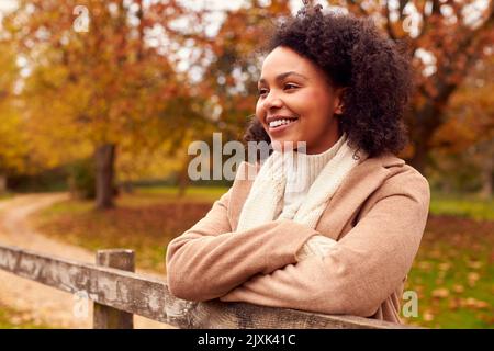 Kopf Und Schultern Porträt Einer Schönen Frau Auf Einem Spaziergang Durch Die Landschaft Des Herbstes, Die Auf Einem Zaun Ruht Stockfoto