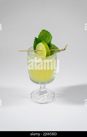 Gelber Alkoholcocktail mit Limette, Minze, Ingwer, Honig, isoliert auf Weiß Stockfoto