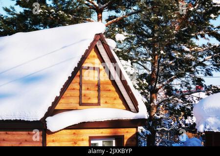 Haus in den alpen zwischen den Bäumen unter der großen Schneeverwehung von weißem Neuschnee. Landschaften und Hintergründe Stockfoto