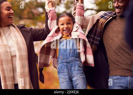 Mutter Und Vater Heben Ihre Tochter Bei Einem Spaziergang Durch Die Herbstliche Landschaft