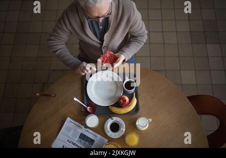 Draufsicht auf einen älteren Mann, der im Pflegeheim frühstückte. Stockfoto