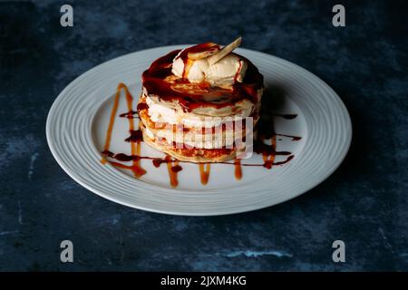 Eine leckere Pfannkuchen mit Banane und Eis auf weißem Teller Stockfoto