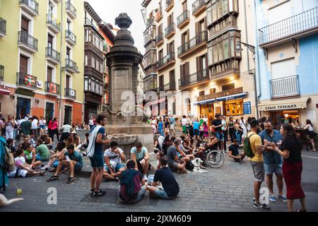 Pamplona, Spanien - Juli 30: Gruppe von glücklichen jungen Menschen, die auf dem Boden sitzen und Bier trinken. Die Freunde genießen eine schöne Zeit zusammen und haben Spaß im N Stockfoto