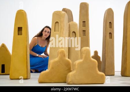 London, Großbritannien. 7. September 2022. Ein Mitarbeiter posiert mit Bienenwachs-Skulpturen in Form von Türmen, Häusern und Zigguraten, die auf Architektur aus dem Nahen Osten, Indien und Südostasien verweisen, bei der Vorschau auf die ‘City of Silence’, eine neue Ausstellung des deutschen Künstlers Wolfgang Laib, in der Galerie Thaddaeus Ropac in Mayfair. Die Ausstellung läuft vom 8. September bis zum 3. Oktober 2022. Kredit: Stephen Chung / Alamy Live Nachrichten Stockfoto