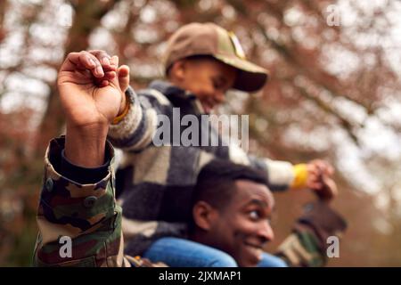 Nahaufnahme Des Amerikanischen Soldaten, Der Mit Einer Army Cap Nach Hause Zur Familie Zurückkehrt Und Den Sohn Trägt Stockfoto