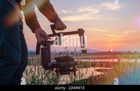 Kameratechniker, der an einem Gimbal arbeitet, um einen Film auf einem kleinen Set zu drehen, um ein glattes Finish zu erhalten. Stockfoto