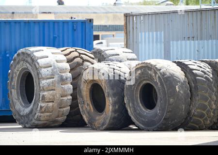 Riga, Lettland - 13. Mai 2022: Sehr große alte gebrauchte LKW-Reifen zum Recycling gestapelt. Umweltverschmutzung durch die Industrie. Stockfoto