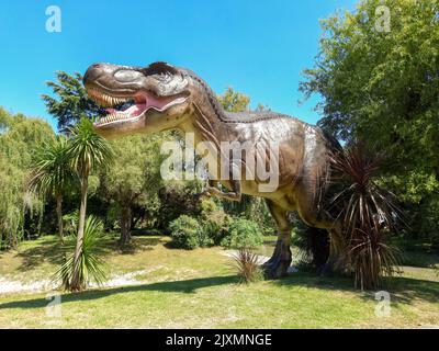 Escobar, Argentinien - 12. März 2022: Prähistorische Dinosaurier-Tyrannosaurus rex-Statue im Blumenausstellungspark. Natur, Grün, Gras, Pflanzen, Bäume Stockfoto