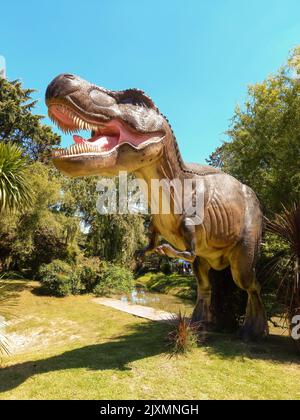 Escobar, Argentinien - 12. März 2022: Prähistorische Dinosaurier-Tyrannosaurus rex-Statue im Blumenausstellungspark. Natur, Grün, Gras, Pflanzen, Bäume. Stockfoto