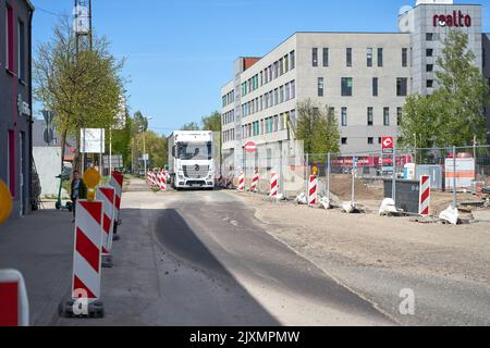 RIGA, LETTLAND - 13. MAI 2022: Weißer schwerer Lkw fährt auf der reparaturbedürftigen Straße Stockfoto