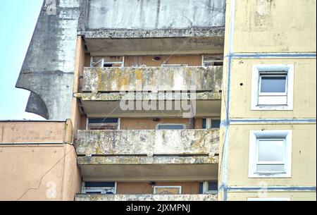 Riga, Lettland - 13. Mai 2022: Stadthochhaus mit verwittertem, moosbedecktem Balkon. Stockfoto