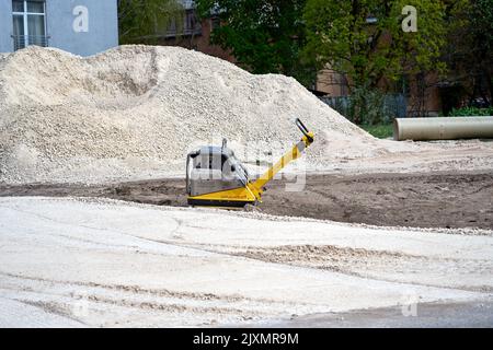 RIGA, LETTLAND - 13. MAI 2022: Vibrationsplatten-Maschine steht allein auf der Baustelle Stockfoto