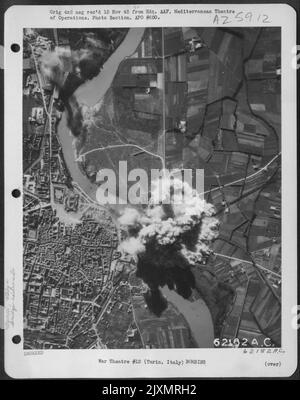 Bomben, die von der nordamerikanischen B-25 Mitchells der 12. Air Force abgeworfen wurden, explodieren auf der Eisenbahnbrücke nördlich von Turin, Italien. Stockfoto