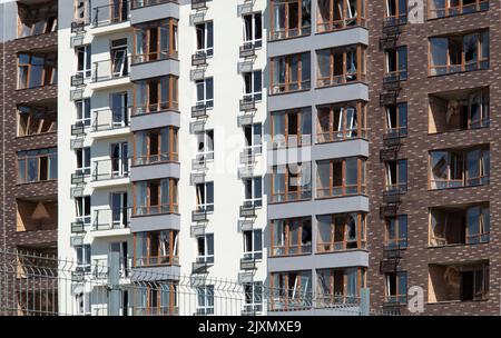 Zerbrochene Fenster des zivilen Wohngebäudes nach der Explosion der russischen Rakete während des russischen Krieges gegen die Ukraine. Kaputte Glasfenster, kaputtes Fenster Stockfoto