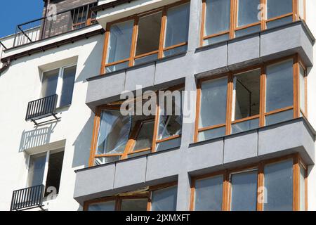 Zerbrochene Fenster des zivilen Wohngebäudes nach der Explosion der russischen Rakete während des russischen Krieges gegen die Ukraine. Kaputte Glasfenster, kaputtes Fenster Stockfoto