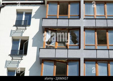 Zerbrochene Fenster des zivilen Wohngebäudes nach der Explosion der russischen Rakete während des russischen Krieges gegen die Ukraine. Kaputte Glasfenster, kaputtes Fenster Stockfoto