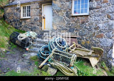 Ausrangierte Angelausrüstung vor einer malerischen kornischen Hütte - John Gollop Stockfoto
