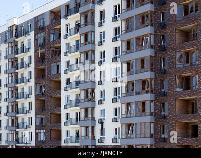 Zerbrochene Fenster des zivilen Wohngebäudes nach der Explosion der russischen Rakete während des russischen Krieges gegen die Ukraine. Kaputte Glasfenster, kaputtes Fenster Stockfoto