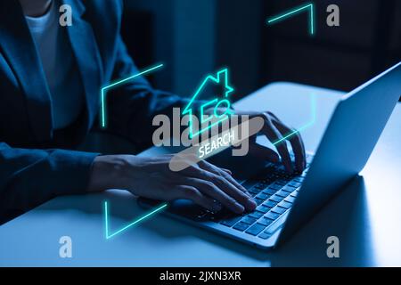 Junger Geschäftsmann im Anzug mit einem Laptop und auf der Suche nach Haus, Immobilien, Wohnung und etc Stockfoto