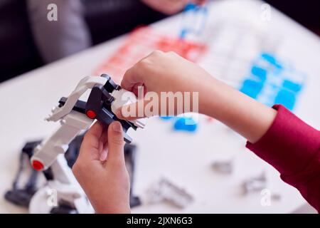 Nahaufnahme Eines Jungen Im Pyjama-Gebäude Roboterarm Aus Kunststoff-Kit Zu Hause Stockfoto