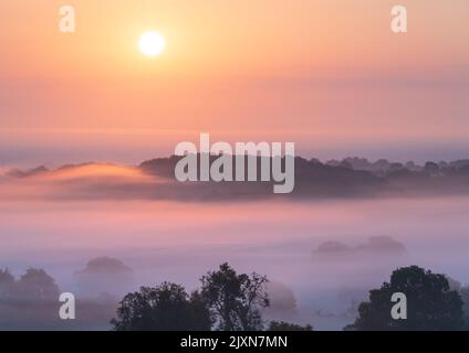Die Sonne geht an einem warmen, späten Sommermorgen über der ländlichen Landschaft am Rande des „The „The“-Stadtkellers „The“ auf. Stockfoto