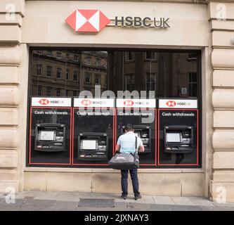 Ein Mann zieht Bargeld von einem HSBC-Geldautomaten in Newcastle upon Tyne, England, Großbritannien, ab Stockfoto