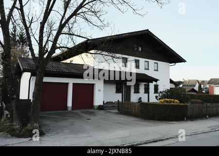 Ein modernes minimalistisches Haus mit Holzzaun und Garagenplatz für zwei Autos Stockfoto