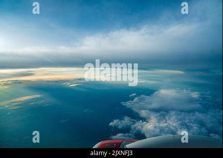 Panorama-Luftaufnahme. Schöner Sonnenuntergang Himmel über Wolken mit dramatischem Licht. Blick auf die Kabine vom Flugzeug aus. Passagierflugzeug. Geschäftsreise. Kommerziell Stockfoto