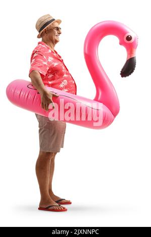 Lange Profilaufnahme eines reifen Touristen mit einem großen aufblasbaren Flamingo Gummiring isoliert auf weißem Hintergrund Stockfoto