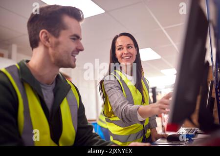 Personal Im Geschäftigen Modernen Lagerhaus, Das An Computerterminals Arbeitet Stockfoto