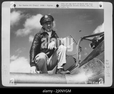 Ein Pilot der 94. Fighter Squadron, 1. Fighter Group, auf seinem Lockheed P-38 Lightning auf einem Luftwaffenstützpunkt irgendwo in Italien. Stockfoto