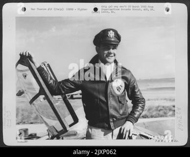 Ein Pilot der 94. Fighter Squadron, 1. Fighter Group, auf seinem Lockheed P-38 Lightning auf einem Luftwaffenstützpunkt irgendwo in Italien. Stockfoto