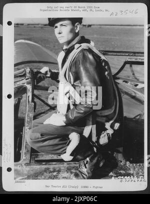 Ein Pilot der 94. Fighter Squadron, 1. Fighter Group, auf seinem Lockheed P-38 Lightning auf einem Luftwaffenstützpunkt irgendwo in Italien. Stockfoto