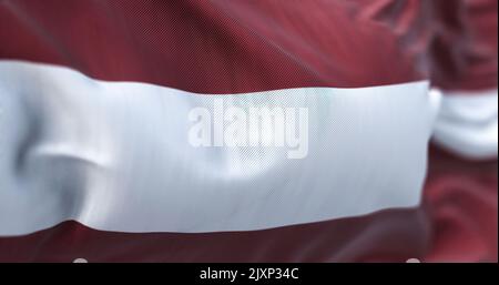 Nahaufnahme der im Wind winkenden lettischen Nationalflagge. Die Republik Lettland ist ein Land im Ostseeraum Nordeuropas. Fabric-Tex Stockfoto