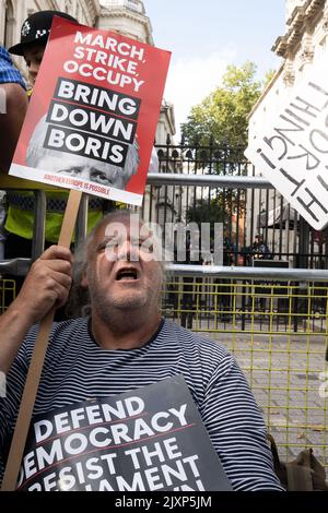 Man sieht einen Mann, der vor der Downing Street protestiert, wo sich Tausende von Menschen versammelt hatten. Stockfoto