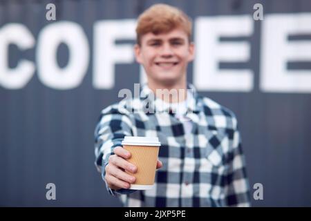 Männlicher Arbeiter, Der Die Mitnehmer Hält, Steht Vor Dem Versandbehälter Mit Der Bezeichnung Kaffee Stockfoto